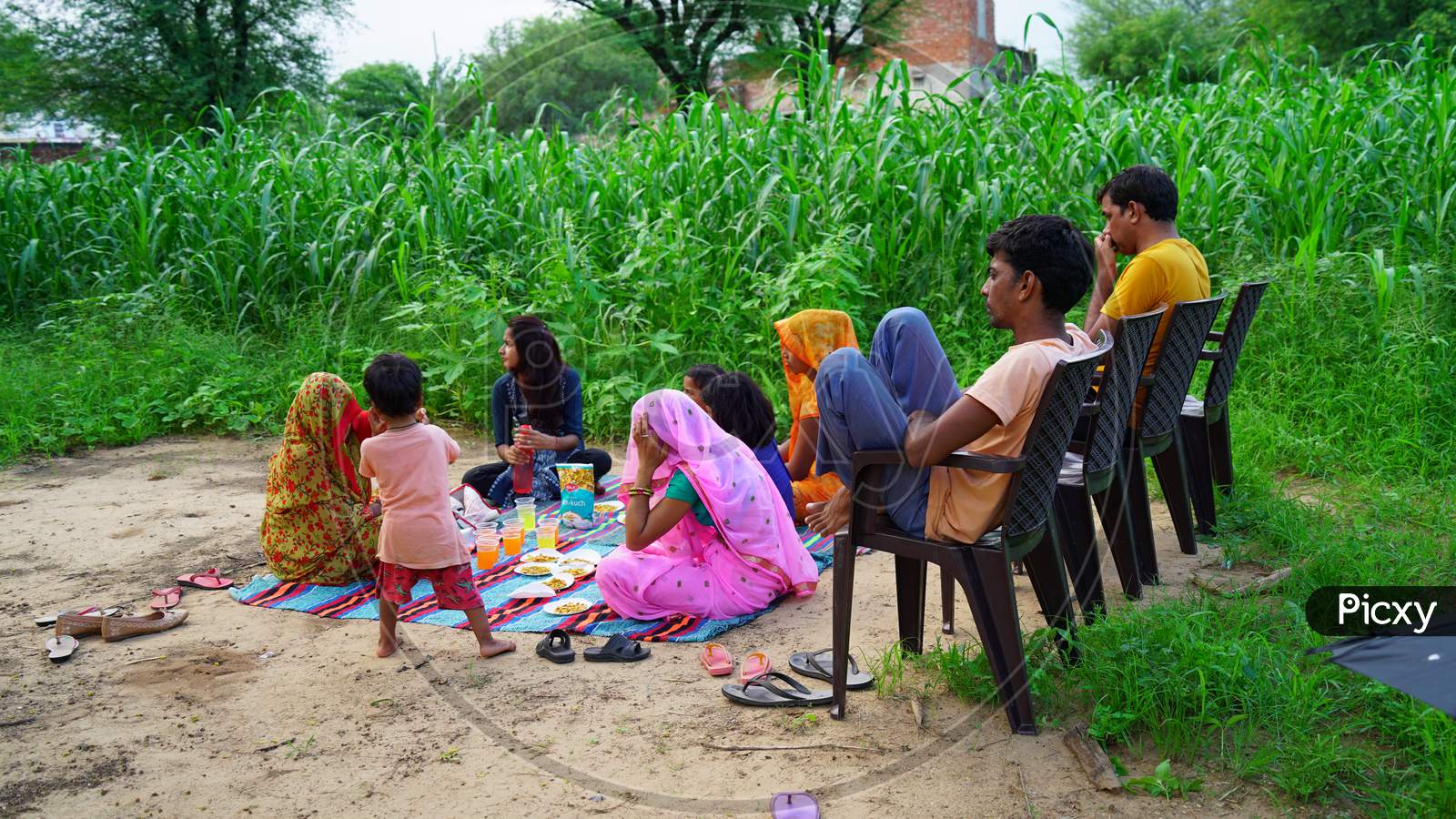 Close up view of traditional Indian family sitting in agriculture farmland.