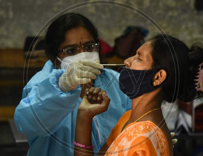 A Health Worker Collects A Swab Sample Of A Woman For The Covid-19 Test, At A Makeshift Swab Collection Center, In Vijayawada On August 28, 2020.