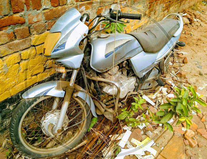 A picture of old and rusted motorbike in backyard