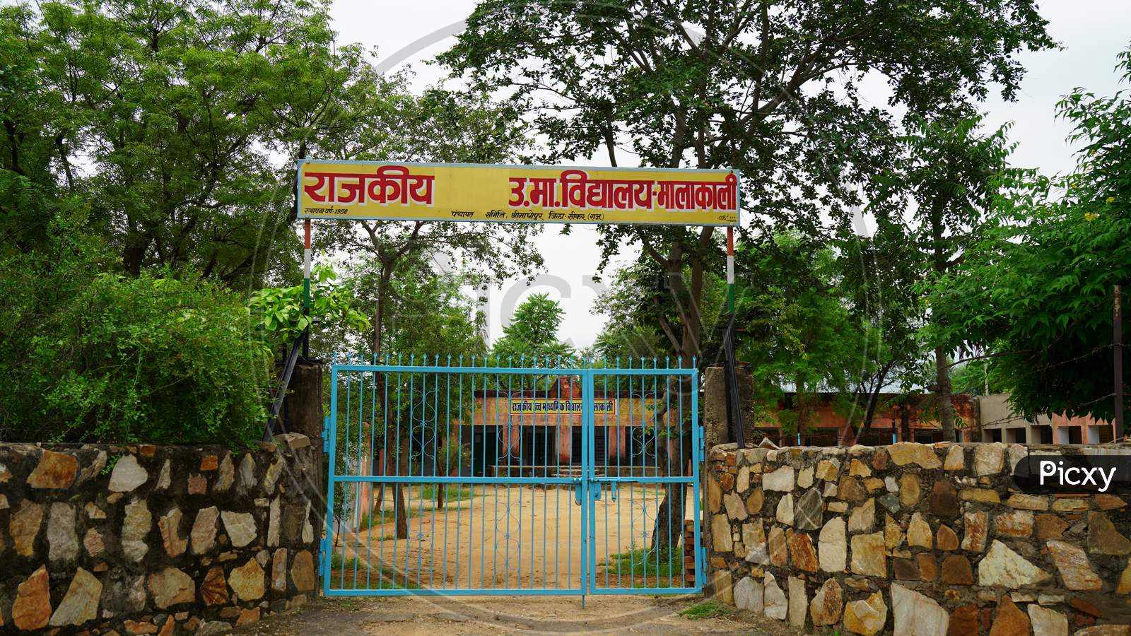 Rear view green colored open Iron gate of school. Stylish enter gate to move forward in the school.