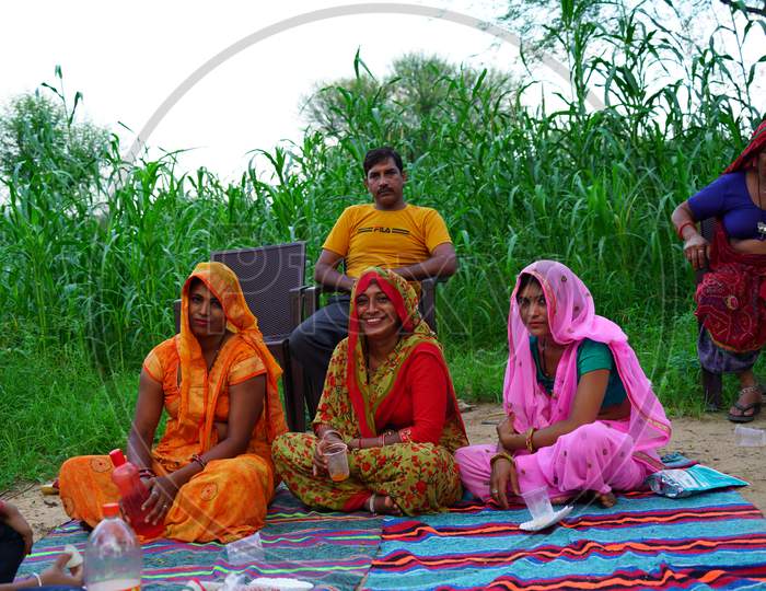 Traditional Indian joint family sitting in a farmland. Enjoying vocational trip. lifestyle concept.