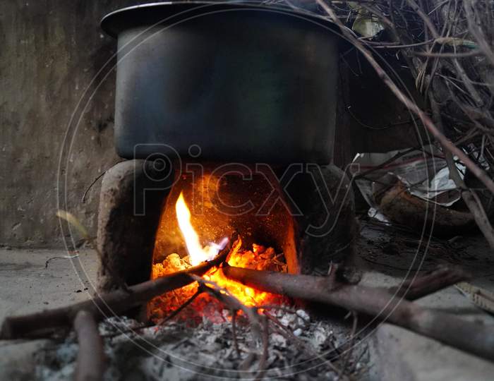 Burning reddish fire in a clay stove with fire wood. Rural India concept.