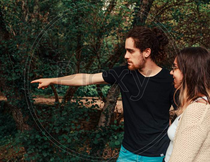Young Man Points Out Something In The Forest To His Partner