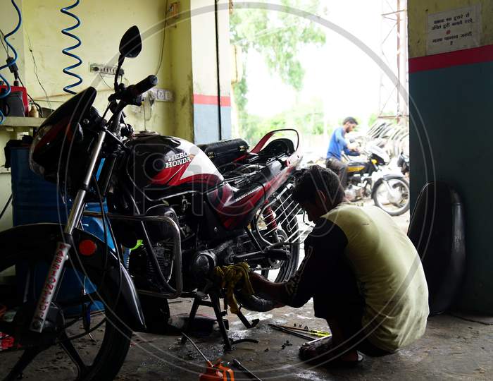 An Indian bike Engineer repairing the bike in a workshop. New modern technology concept.