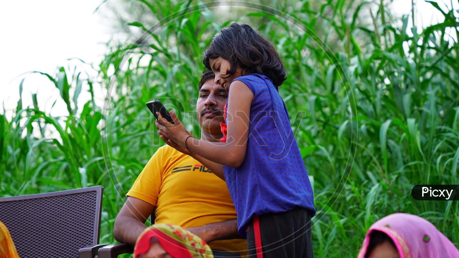 Cheerful little girl showing smart phone to her father.