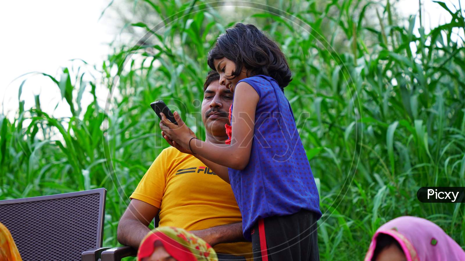 Cheerful little girl showing smart phone to her father.