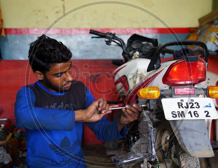 Reengus, Jaipur, India-11 March 2020; An Indian Mechanic repairing bike on a workshop. Modern bike engineer.