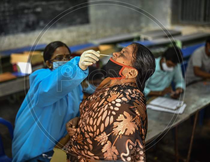 A Health Worker Collects A Swab Sample Of A Woman For The Covid-19 Test, At A Makeshift Swab Collection Center, In Vijayawada On August 25, 2020.
