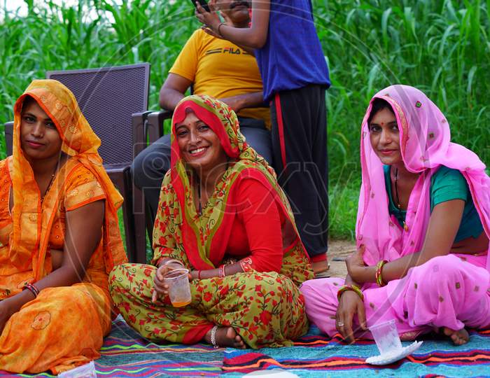 Cheerful Indian family sitting in a farmland and enjoying a trip. Indian lifestyle concept.