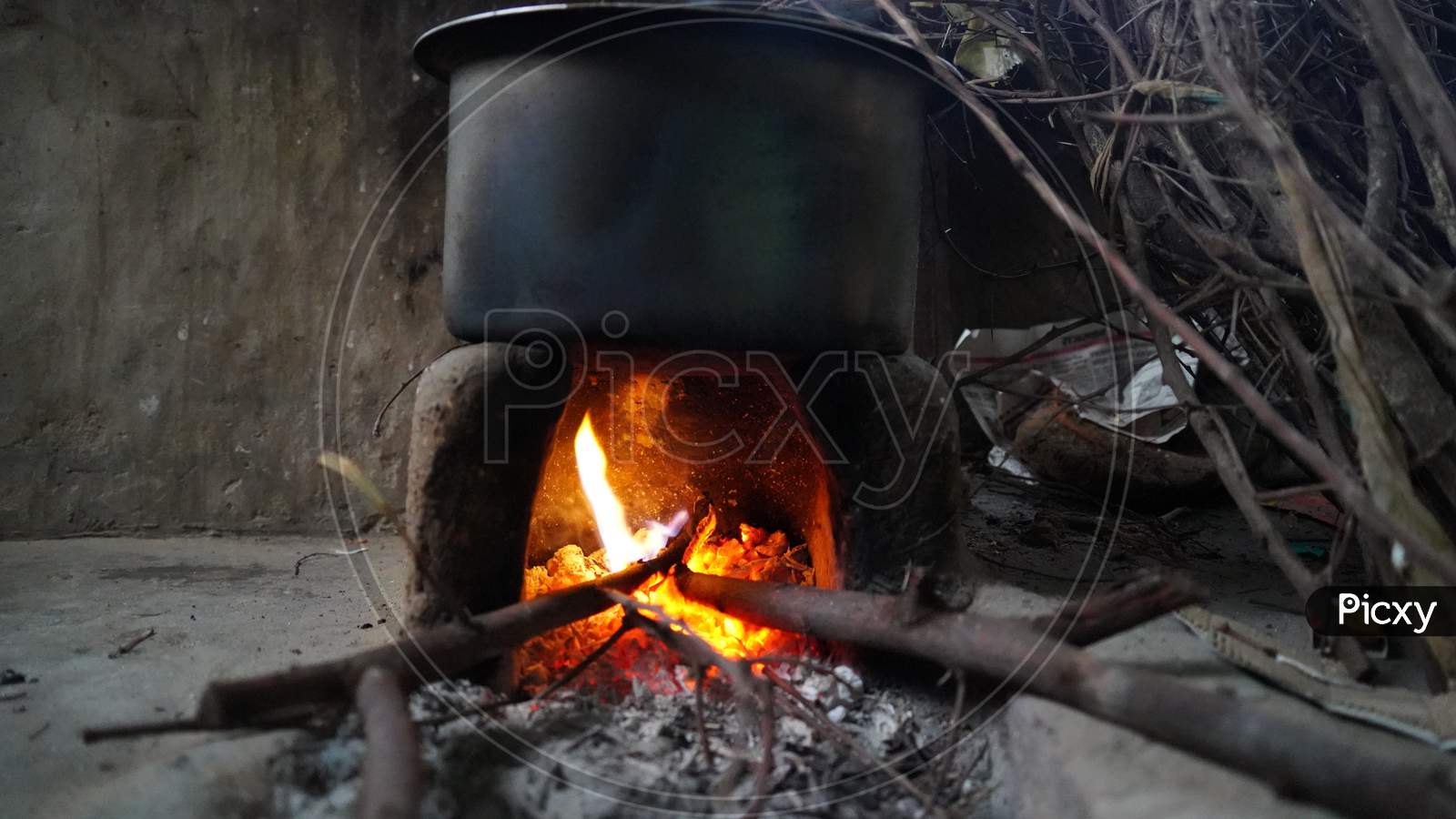 Burning reddish fire in a clay stove with fire wood. Rural India concept.