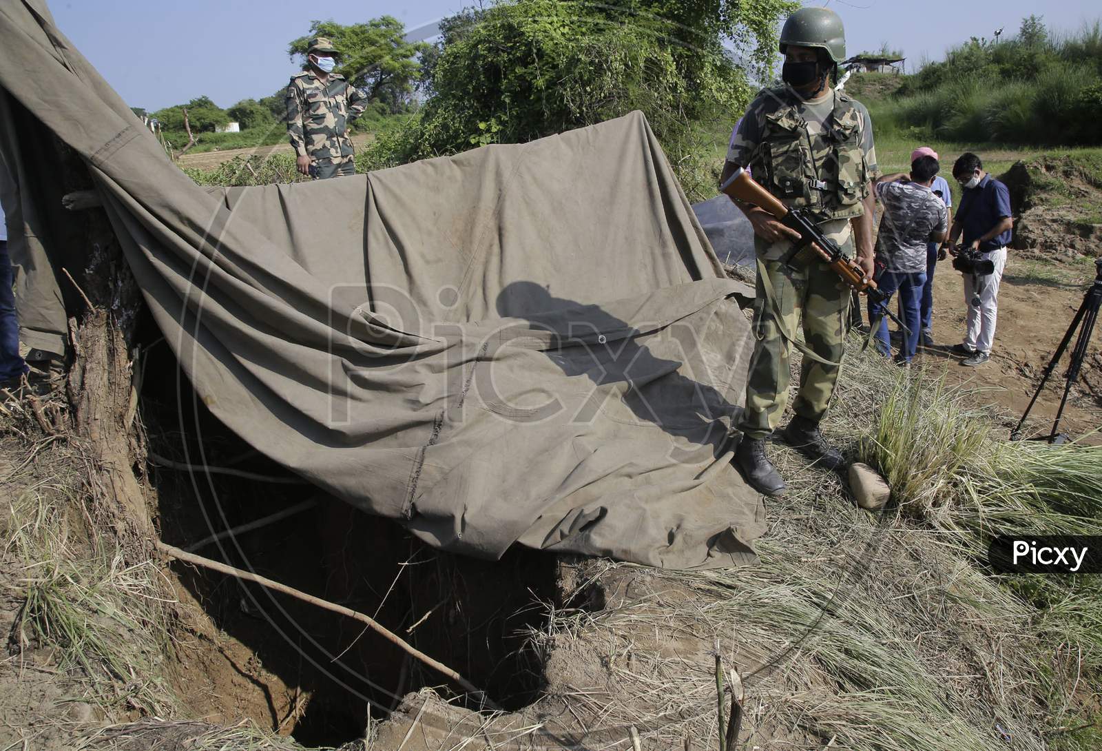 Border Security Force (BSF) personnel stand near a tunnel, originating from Pakistan, beneath the Indo-Pak international border fence, in J&K's Samba district,  Aug. 29, 2020.