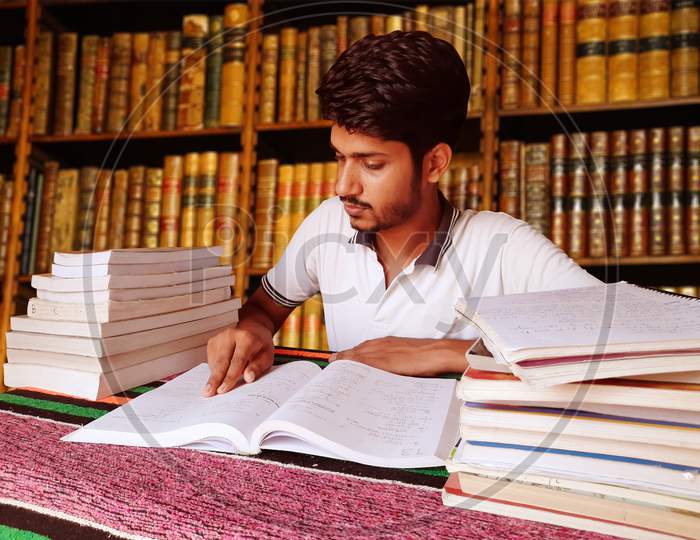 Student Studying Hard For Exams In Library