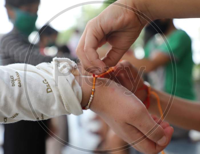 Girls tie rakhi on the wrists of boys of an orphanage on the occasion of Raksha Bandhan Festival in Jammu on August 3, 2020.