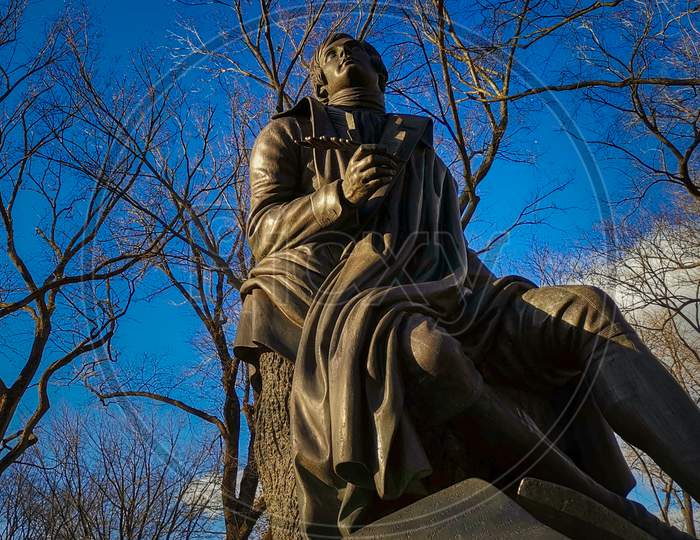Robert Burns statue (by John Steell)  in Central park New York city daylight view with trees and clouds in sky