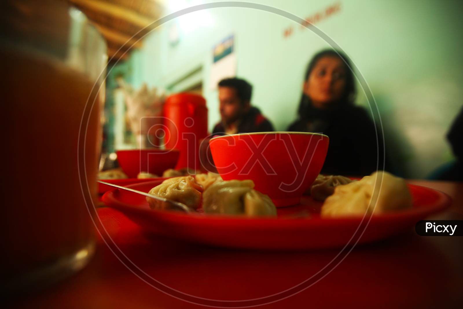 Close up shot of a Momos Plate with People in the Background