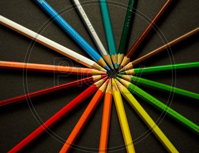 A Bunch Of Colorful Pencils Touching Each Others Heads
