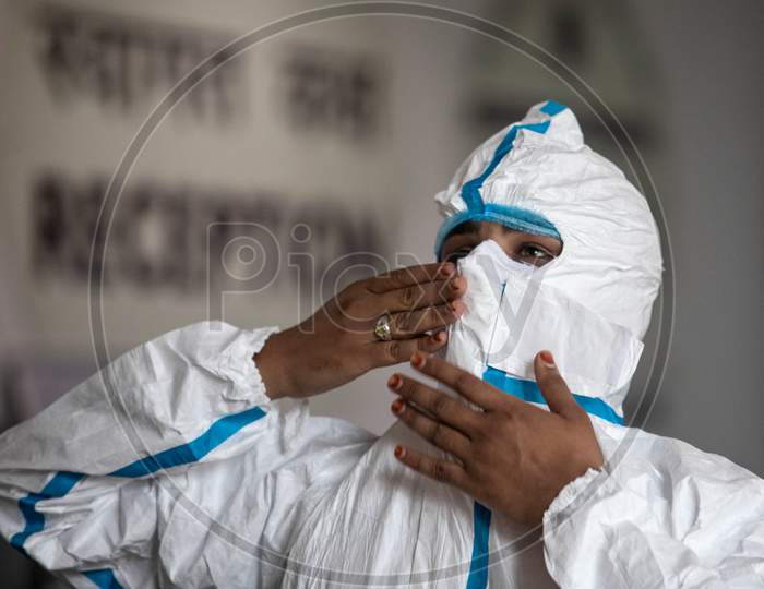 A health worker helps her colleague wear a PPE suit before entering the isolation wards at the Commonwealth Games Village Sports Complex which has been temporarily converted into a Coronavirus Care Centre in New Delhi on August 3, 2020