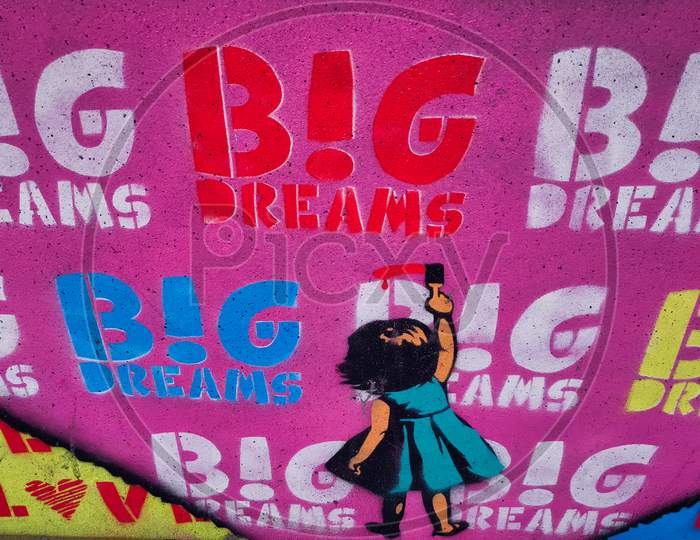 Mural art (graffiti) showing a little girl (from the back) writing I LOVE BIG DREAMS