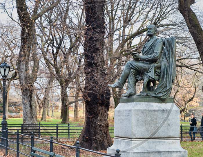Fitz Greene Halleck Statue (by  James Wilson Alexander MacDonald)  in Central park New York city daylight view with trees and clouds in sky
