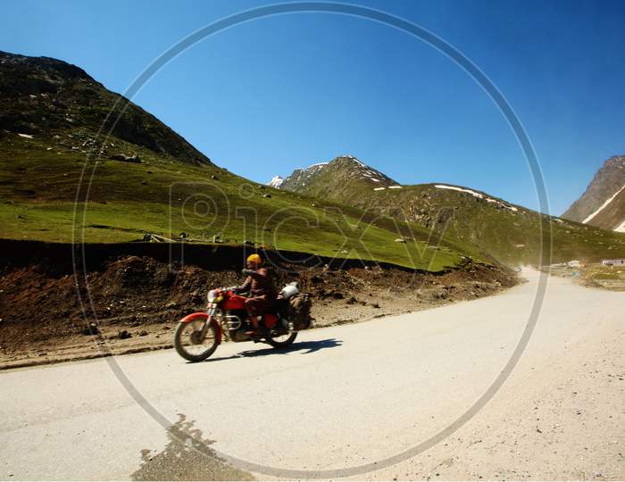 Bike Rider Riding Across a Highway Of Ladakh