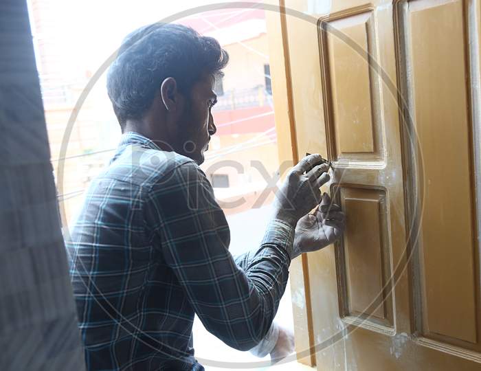 Jodhpur, Rajasthan, India, 20Th September 2020: Young Indian Carpenter Doing Finishing Of Wooden Door With Dirty Hands Wearing Casual Clothes, Woodwork Labour Concept.