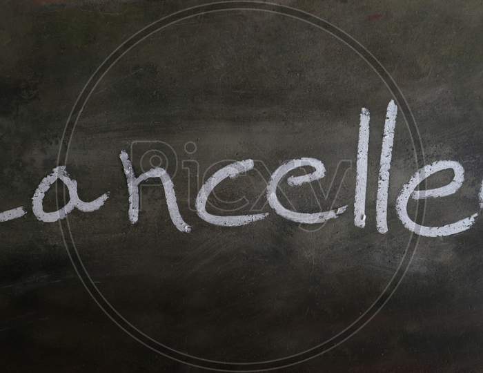 Cancelled Word Written On Blackboard With Chalk