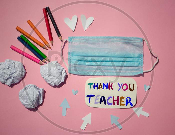 Thank You Teacher Written On Paper Note With Medical Face Mask And Color Pencils, Happy Teacher's Day Conceptual Photo