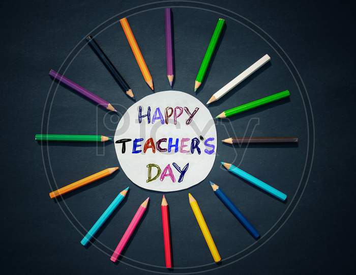Happy Teacher's Day Creative Photo With Color Pencils On Black Background, Perfect For Wallpaper