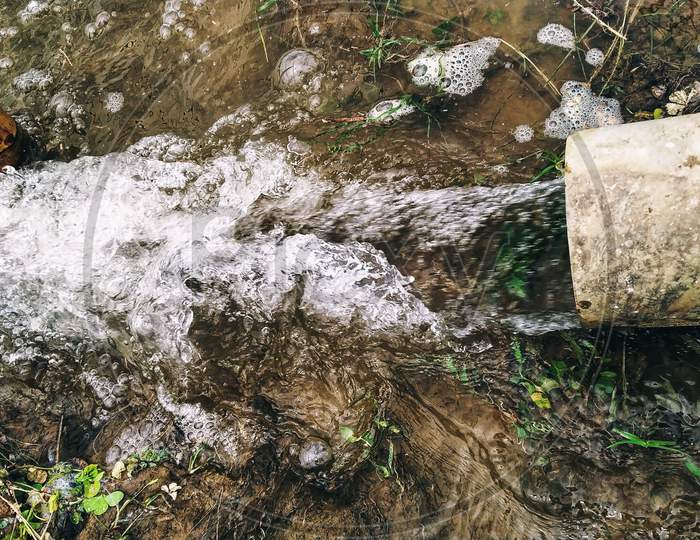 Water flowing from pipe to a farm land