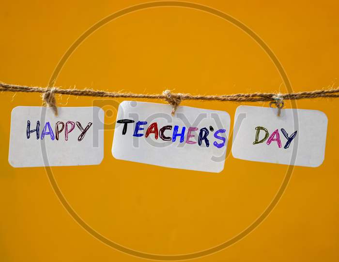 Happy Teacher's Day Wishing Photo With Paper Note Isolated In Yellow Background, Perfect For Wallpaper