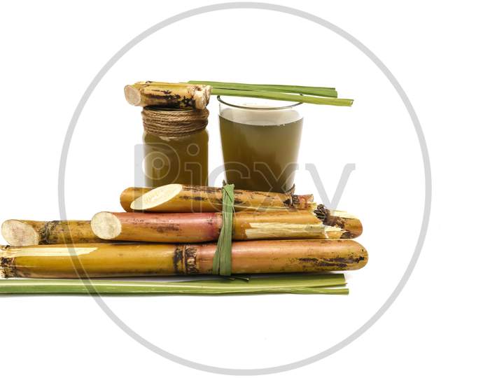 Sugarcane Juice In Glass Jar With Sugarcane Pieces Isolated On White Background In Horizontal Orientation