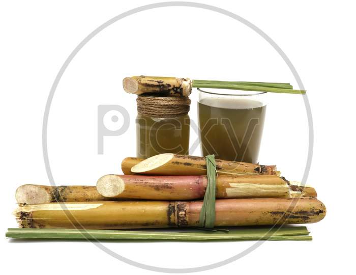 Sugarcane Juice In Glass Jar With Sugarcane Pieces Isolated On White Background In Vertical Orientation