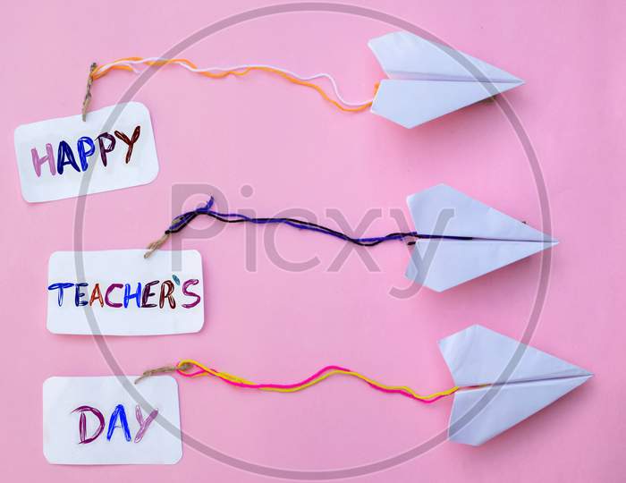 Happy Teacher's Day Creative Photo With Paper Airplanes On Pink Background