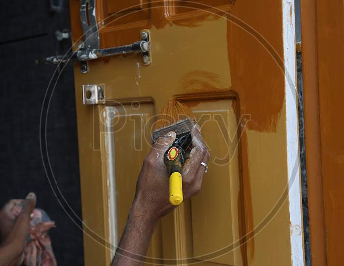 Close Up Of Indian Male Hands Painting Wooden Door Holding Paint Brush, Painting Planks/Boards, Back To Work After Lockdown Ends In India.