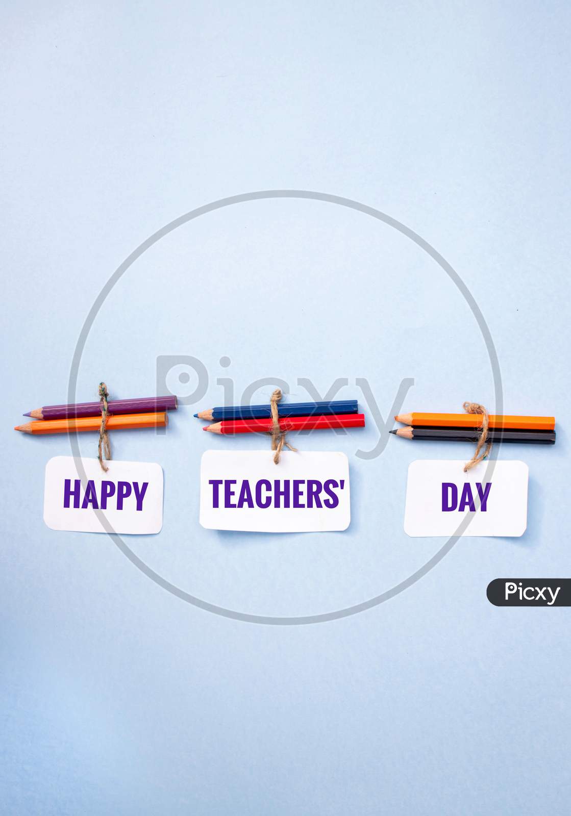 Happy Teacher's Day Wish Written On Paper Note With Color Pencils On Pink Background