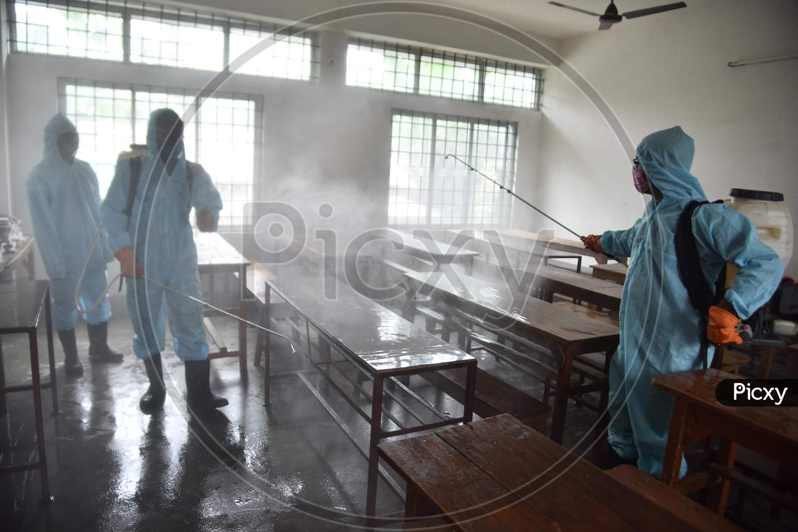 Municipal workers wearing personal protective equipment (PPE) spray disinfectant to sanitize a  school  to prevent the spread of the coronavirus disease (Covid-19) In Nagaon district of Assam on August 30,2020.