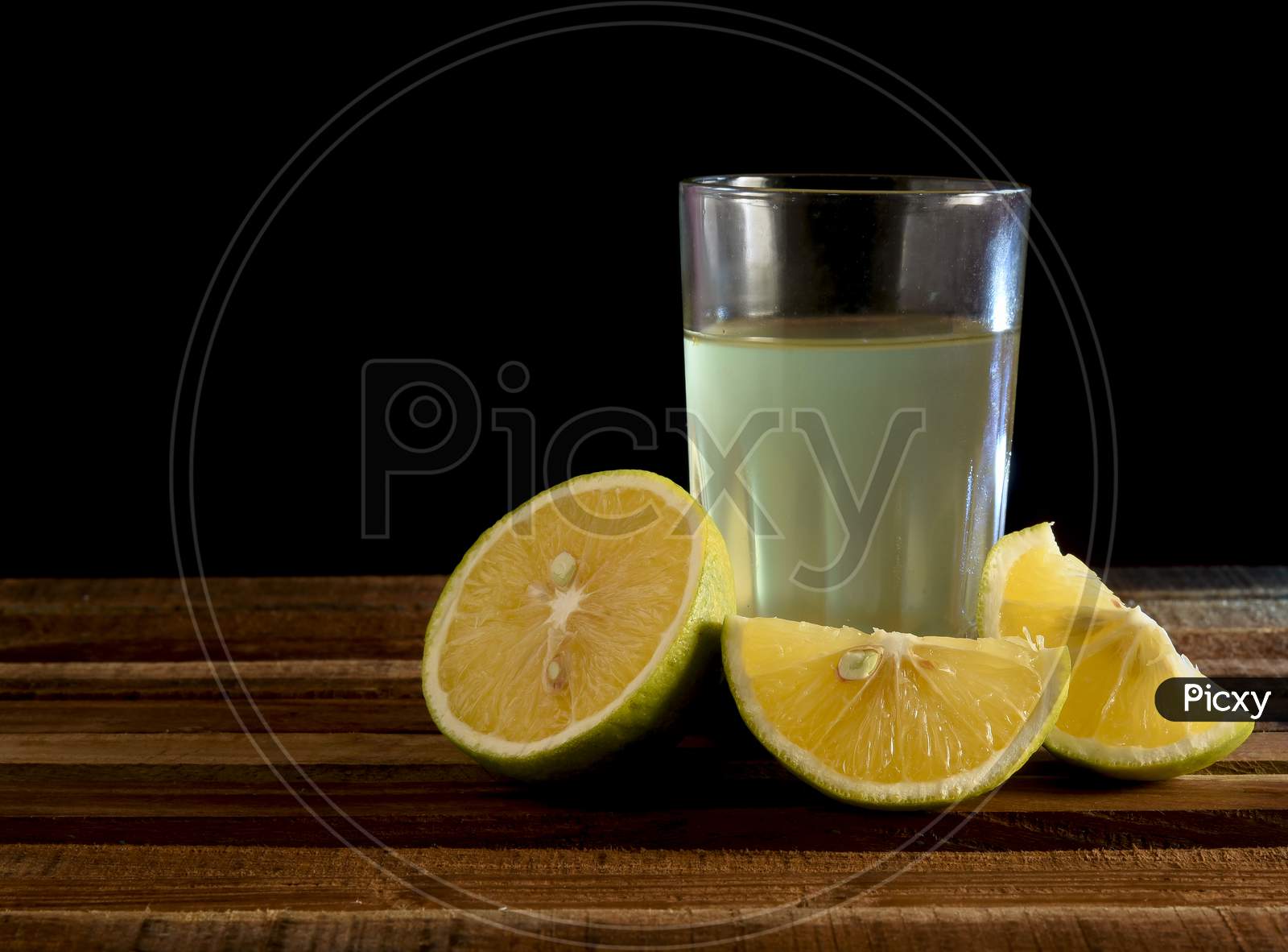 Glass of orange juice and oranges on wooden background