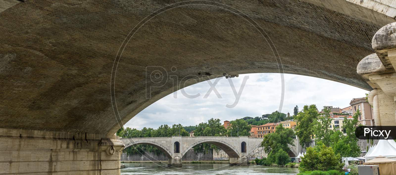 Italy, Rome, A Bridge On The Tiber River Viewed Below Arch Of Another Bridge