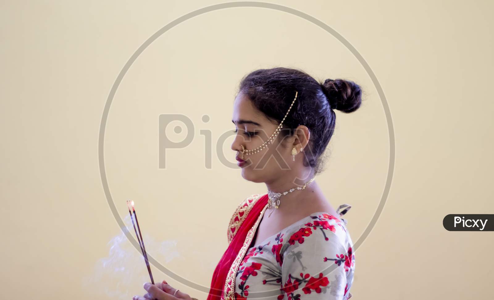 A Beautiful Young Hindu Girl With Incense Sticks Burning With Smoke And Gold Ornaments According To Her Traditions And Customs