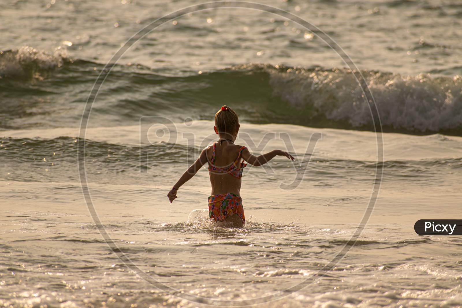 a girl is bating at the beach of goa,india