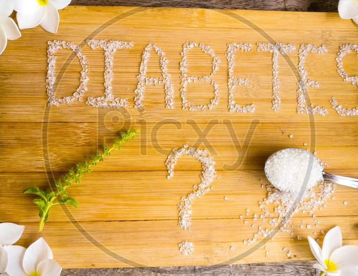 Diabetes written on the wooden table giving massage stay healthy.used spoon of sugar, flowers, wooden table,