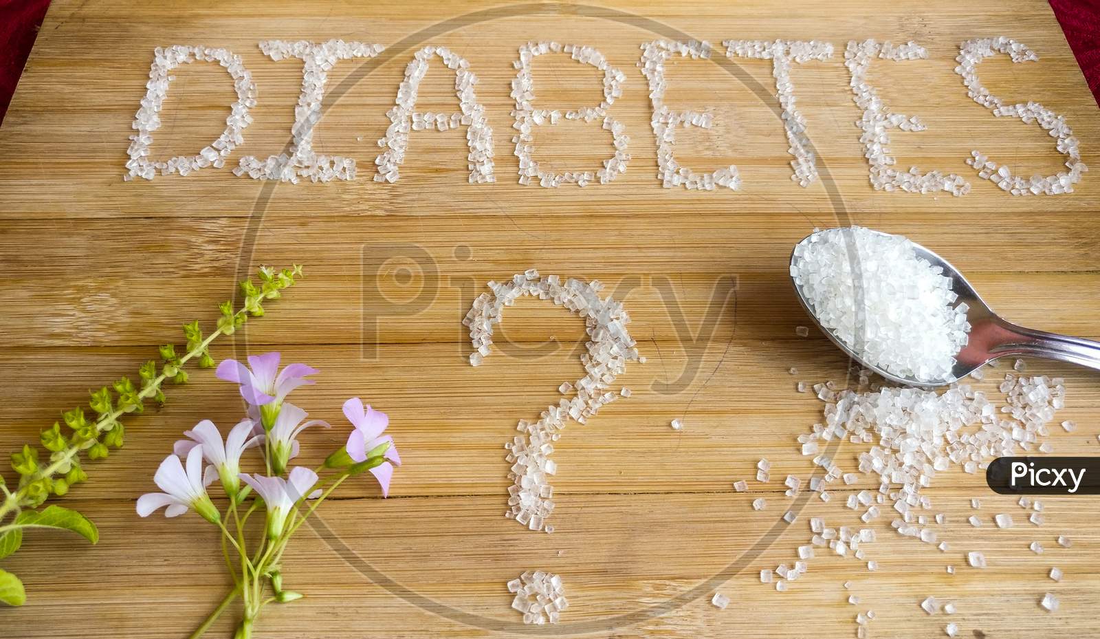Diabetes written on the wooden table giving massage stay healthy.used Basil, spoon of sugar, flowers, wooden table