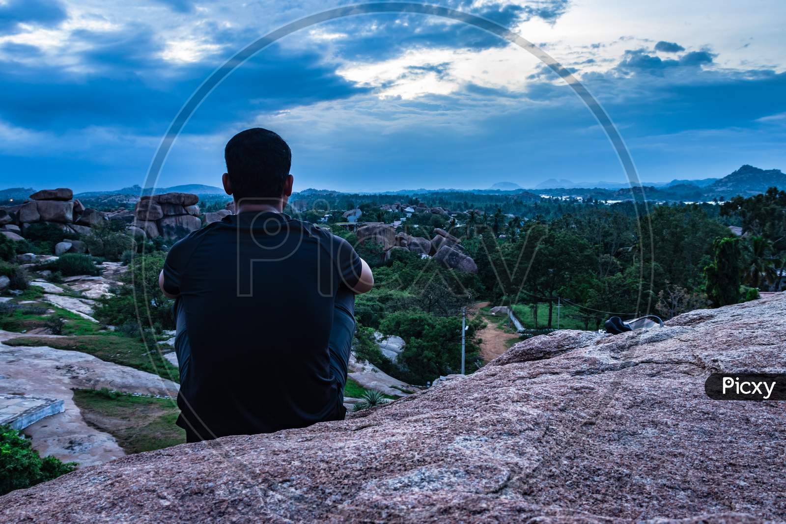 Man Sitting At Mountain Top Watching Sunset With Dramatic Sky At Morning Flat Angle Shot