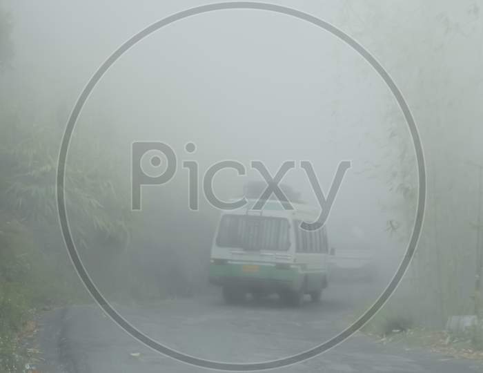 A bus passing through a foggy road