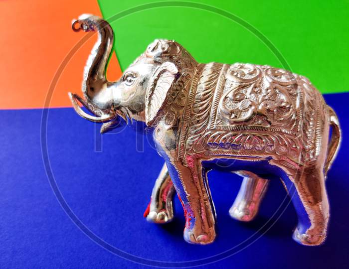 Silver Color Standing Elephant Toy Isolated On Blue Background.Selective Focus