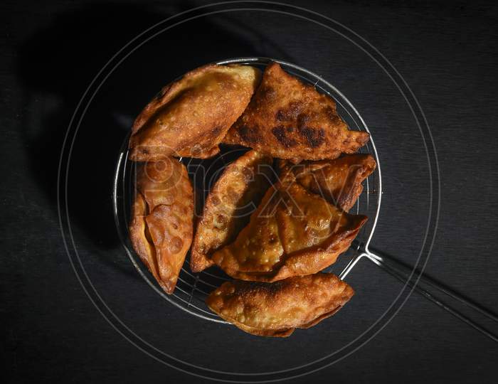 samosa on a plate with sauce and tomatoes. horizontal view from above, rustic style