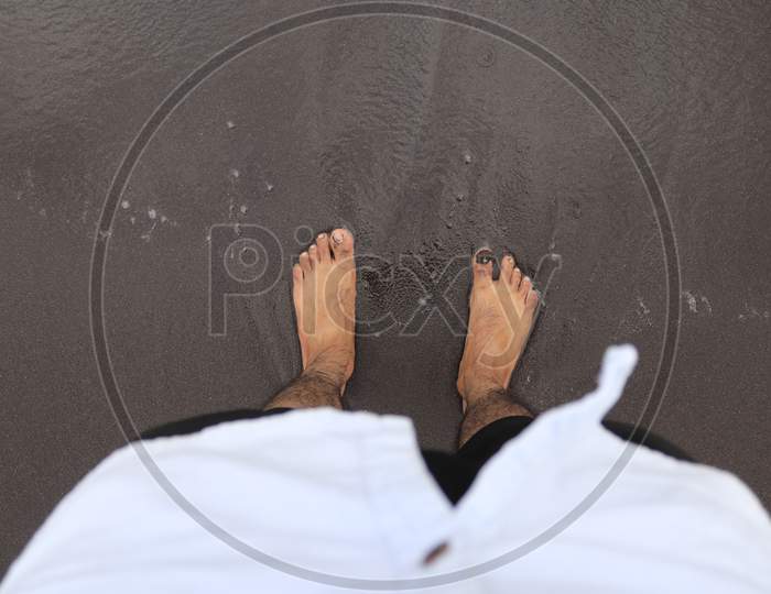 Young Man standing on the Black Sand Beach