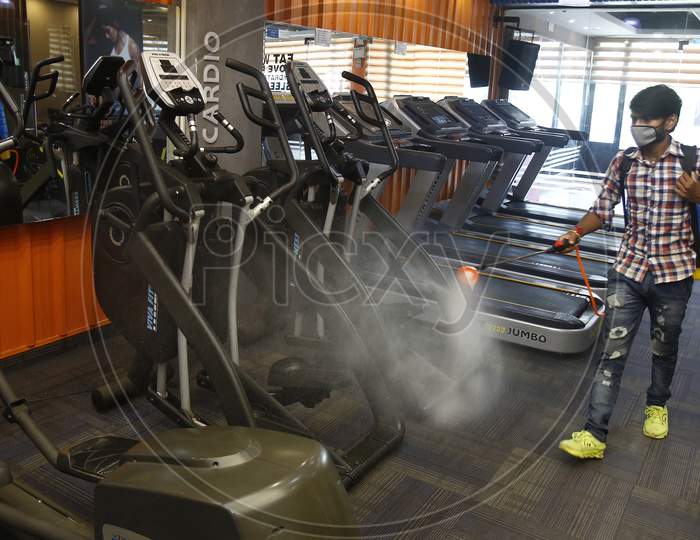 A man sanitizes a gym before its reopening in Chandigarh, August 4, 2020