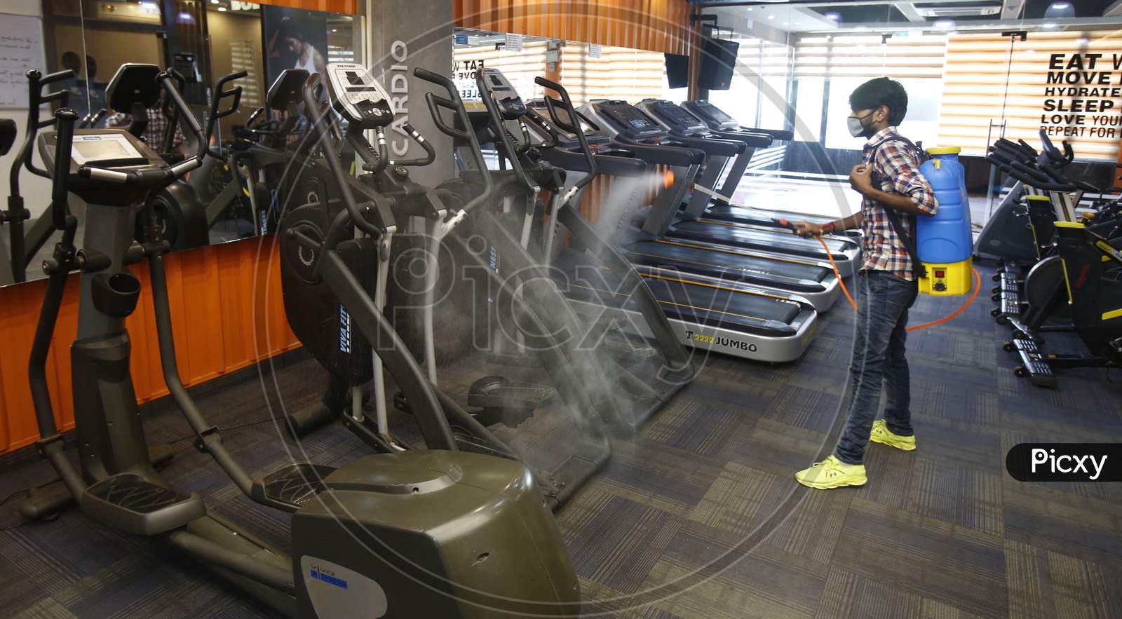 A man sanitizes a gym before its reopening in Chandigarh, August 4, 2020
