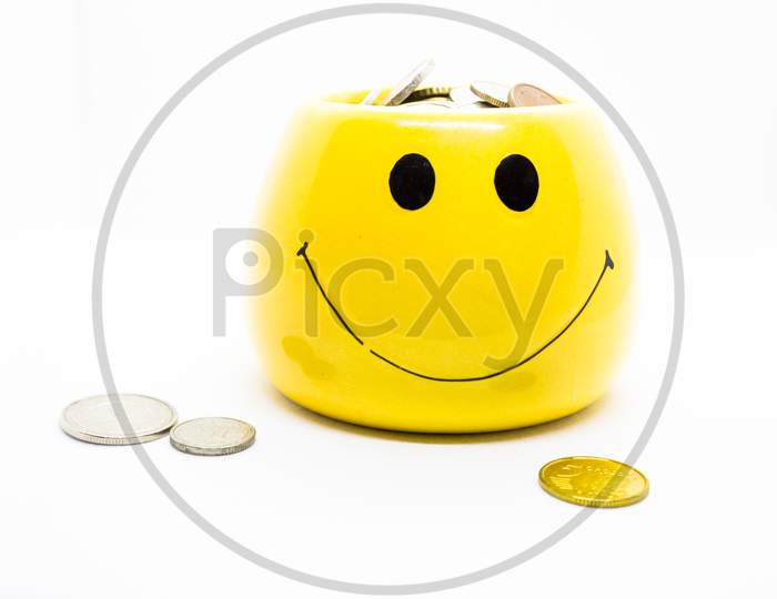 Image Representing Money Saving And It'S Benefit By Portraying Coins In A Yellow Cup With Smiley